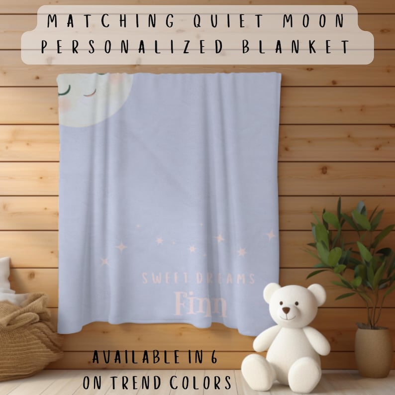 May include: A light blue personalized blanket with a moon and star design. The blanket has the text "Sweet Dreams Finn" and "Matching Quiet Moon Personalized Blanket" printed on it. A white teddy bear sits in front of the blanket. Available in 6 on-trend colors.