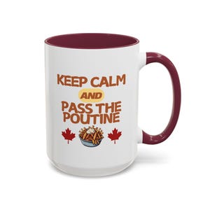 May include: White ceramic mug with a maroon rim and handle. The mug features the text "Keep Calm and Pass the Poutine" with a cartoon image of poutine and two Canadian maple leaf icons.