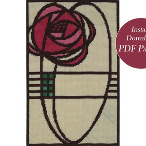 May include: A needlepoint pattern featuring a stylized rose in shades of pink and red, surrounded by a black and brown geometric frame. The background is a cream color.