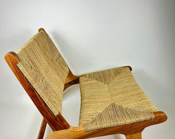 Pode incluir: Uma cadeira de madeira com assento e encosto tecidos. A cadeira tem um acabamento em madeira natural e um design simples e moderno.