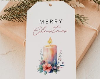 May include: A white gift tag with the words "MERRY Christmas" and "YOUR FRIEND, MARTY" printed on it. The tag features a watercolor illustration of a candle with a flame, surrounded by flowers and greenery. The tag is tied to a wrapped gift with twine and evergreen sprigs.