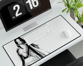 Puede incluir: Alfombrilla de escritorio rectangular blanca con borde negro, con una ilustración manga en blanco y negro. Un teclado y un ratón blancos están sobre la alfombrilla. Un monitor de ordenador y una planta son visibles en el fondo. La hora es 14:16.