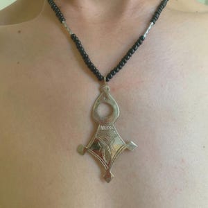 Grote handgemaakte Berber Toeareg-ketting: etnische Marokkaanse sieraden met gegraveerde hanger van metaallegering en zwarte kralen, symbolisch cultureel cadeau