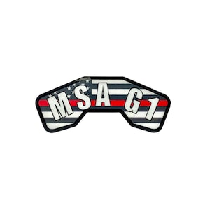 Puede incluir: Un parche de bandera estadounidense en blanco y negro con una franja roja y el texto "MSG1" en letras blancas.