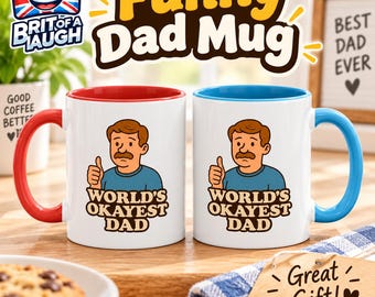 May include: Two white ceramic mugs featuring a cartoon illustration of a man with a mustache giving a thumbs up. Below the illustration, the text reads World's Okayest Dad. One mug has a red handle and interior, while the other has a blue handle and interior.