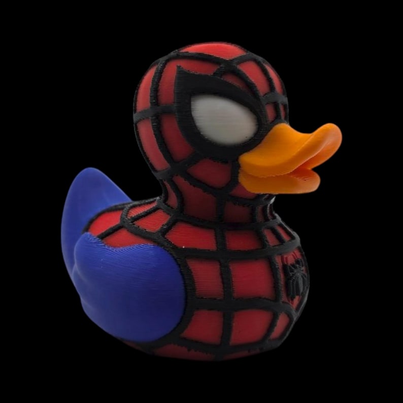 以下が含まれることがあります： スパイダーマン風のノベルティラバーダック。アヒルは、黒いウェブ、青い翼、オレンジ色のくちばしが付いた赤い体を持っています。目は白く、小さなクモのエンブレムが側面にあります。