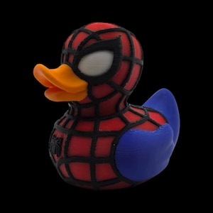 以下が含まれることがあります： スパイダーマン風のノベルティラバーダック。アヒルは赤と黒のウェブマスク、白い目、オレンジ色のくちばしが特徴です。体は赤で黒のウェブと青い翼が付いています。胸には小さなクモのエンブレムが付いています。