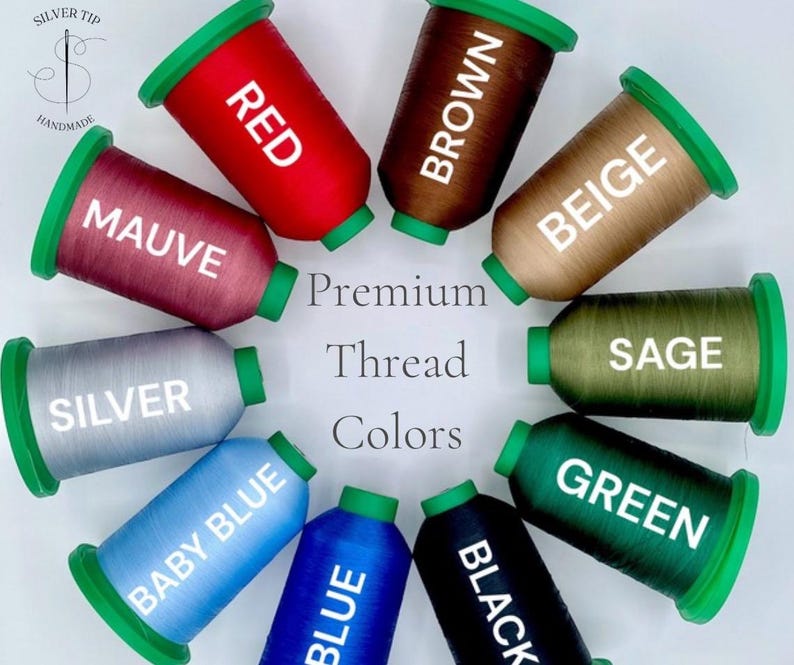 May include: A collection of spools of premium thread in various colors, including red, brown, beige, mauve, silver, baby blue, blue, black, sage, and green. Each spool has a green cap and is labeled with its color name. The text "Premium Thread Colors" is also visible.