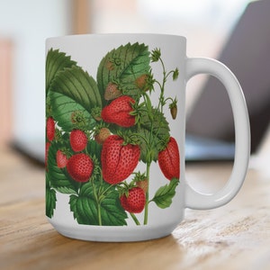 Puede incluir: Taza de cerámica blanca con una ilustración botánica de fresas rojas y hojas verdes. La taza tiene un asa grande y un acabado brillante. El diseño es una impresión botánica de estilo vintage, ideal para té o café. La taza mide aproximadamente 10 cm de alto.