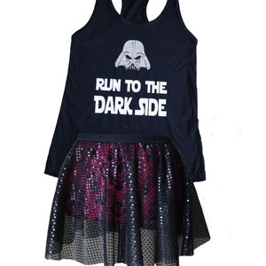 Puede incluir: Camiseta negra de tirantes con un gr&aacute;fico de Darth Vader en purpurina plateada y el texto "Run to the Dark Side". Una falda de lentejuelas negra y burdeos se superpone a la camiseta.