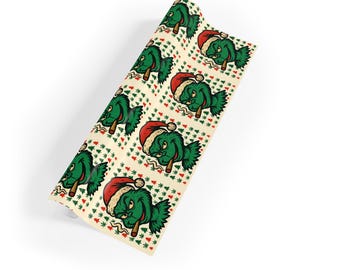 May include: A roll of wrapping paper featuring a repeating pattern of green fish wearing Santa hats and smoking cigars. The background is a cream color with red and green Christmas tree and leaf accents.