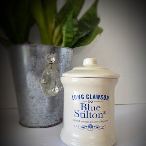 Puede incluir: Un tarro de cerámica blanco con una etiqueta azul y blanca que dice "Long Clawson Blue Stilton Stilton® makers for over 100 years since 1730".