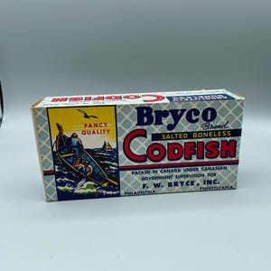 Könnte beinhalten: Vintage Bryco Brand Kabeljau-Box. Die Box hat ein blau-weißes Rautenmuster mit rotem und blauem Text. Die Box zeigt eine Illustration eines Bootes mit einer Person beim Angeln. Der Text lautet "Fancy Quality".