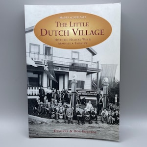 Peut inclure: Couverture de livre intitulée "The Little Dutch Village", avec une photo sépia d'une scène de village historique. Le texte de la couverture comprend "Images of Our Past" et "Historic Halifax West: Armdale • Fairview". Auteurs : Devonna & Don Edwards.