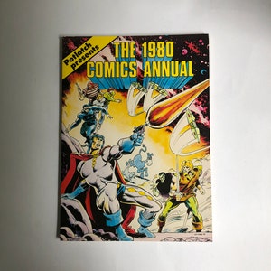 May include: A comic book cover featuring a group of superheroes in a space setting. The cover is titled "The 1980 Comics Annual" and features a yellow and red colour scheme.