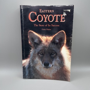 May include: A book titled "Eastern Coyote: The Story of Its Success" by Gerry Parker. The cover features a close-up photograph of a coyote looking directly at the camera.