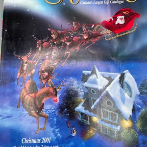 May include: The cover of the Sears Wish Book Christmas 2001 catalog features Santa Claus in his sleigh pulled by reindeer over a snowy landscape. The catalog cover has the text "Wish Book" in gold lettering.