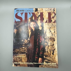 May include: A 1990 Autumn/Winter Sears Catalog Style magazine featuring a cover image of a person wearing a dark brown turtleneck sweater and a long black coat with a red floral pattern, with the text Sears Catalog Style printed at the top.
