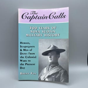 Può includere: Una copertina di libro con uno sfondo blu chiaro e il titolo "The Captain Calls: 300 Years of Nova Scotia Military History." Il sottotitolo è "Heroes, Scapegoats & Men of Duty: From the Colonial Wars to the Present Day." L'autore è Brent Fox. Una foto in bianco e nero di un uomo in uniforme militare si trova sul lato destro della copertina.