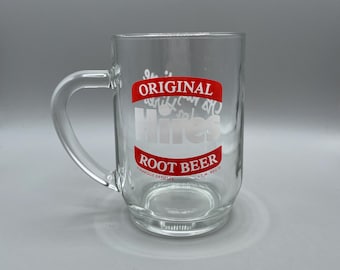 May include: A clear glass mug with a handle featuring the red and white Hires Original Root Beer logo printed on the front. The design includes the text Original, Hires, and Root Beer, along with the small print Marque Deposee and T.M. Reg'd.