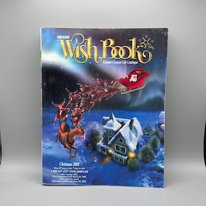 Puede incluir: Un catálogo navideño Sears Wish Book de 2001 con un cielo nocturno azul oscuro, auroras boreales, una casa cubierta de nieve y Santa Claus en un trineo rojo tirado por renos. El texto dice Sears Wish Book Canada's Largest Gift Catalogue.