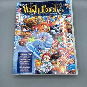 May include: A Sears Wish Book catalog cover from Christmas 2002, featuring a collage of cartoon characters including a teddy bear, lion, giraffe, and panda. The catalog's title is in gold script, with text indicating it is Canada's largest gift catalog.