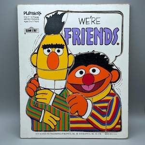 May include: Vintage Playskool Sesame Street puzzle featuring Bert and Ernie. The puzzle shows the characters hugging, with the words "WE'RE FRIENDS" in a speech bubble. The puzzle is made of wood and is designed for ages 2 to 5 years.