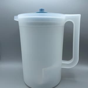 May include: A white plastic pitcher with a handle and a lid. The pitcher has a large capacity and a light blue lid and handle. The pitcher is designed for serving beverages.