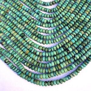 May include: Close-up of multiple strands of turquoise beads. The beads are small, round, and a mix of light and dark turquoise colors. The strands are arranged in a flowing, layered pattern, creating a textured and visually appealing display. The beads are likely used for jewelry making.