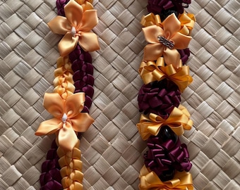 Collar trenzado hawaiano con cintas y nueces de kukui, ideal para celebraciones de graduación.