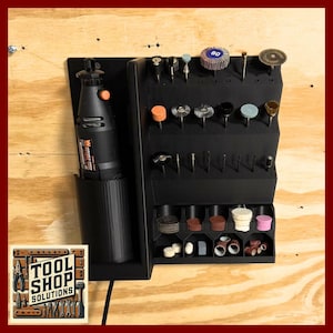 May include: Black rotary tool organizer with various bits and accessories. The organizer includes a holder for the rotary tool and multiple slots for different types of bits. The image also shows the "Tool Shop Solutions" logo.