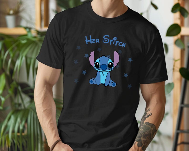 Puede incluir: Camiseta negra con un personaje azul Stitch de la pel&iacute;cula de Disney Lilo & Stitch. La camiseta tiene el texto "Her Stitch" y un patr&oacute;n de estrellas blancas.