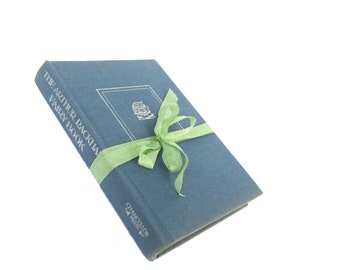 May include: A blue hardcover book titled "The Arthur Rackham Fairy Book" with a green ribbon tied around it.
