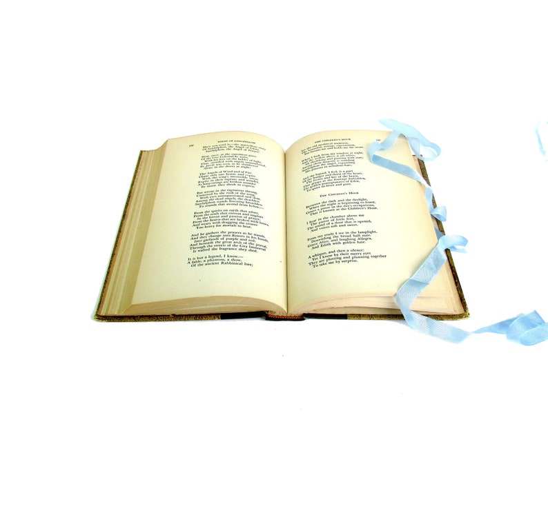 May include: An open book with a light blue ribbon bookmark. The pages contain poetry with the titles "The Heart of the Hills" and "The Chimney Sweeper".