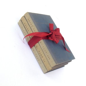 May include: A set of five books bound in blue cloth with a red ribbon tied around them. The spines of the books are labeled "Henry the Fifth" and "Part I", "Part II", "Part III".