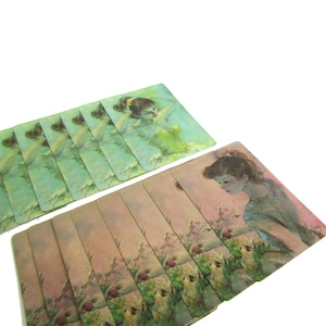 May include: A set of vintage playing cards featuring a woman in a green dress with a floral design. The cards are in a stack and have a light green background with the word "Gypsy" written on them.