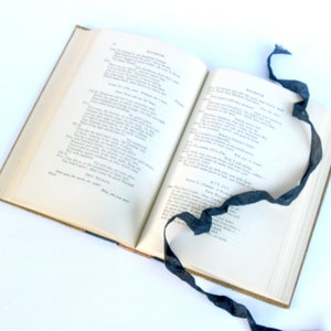 May include: An open book with a black ribbon bookmark. The book is titled "Macbeth" and the pages contain text from Act III, Scene 1.