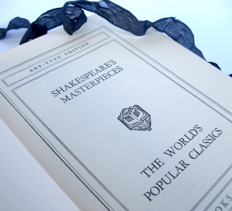 May include: A white book with the title "Shakespeare's Masterpieces" and the subtitle "The World's Popular Classics" printed on the cover. The book is part of the "Art-Type Edition" series.