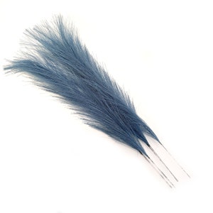 May include: A bunch of three blue ostrich feathers with long, thin stems.