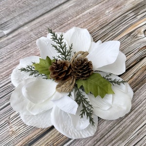 Clip de flor de magnolia blanca de invierno con diseño de bosque: adorno de piña y hojas de acebo