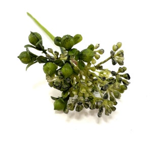 May include: A sprig of artificial greenery featuring clusters of small, round, green buds and tiny, off-white flowers. The stem is a light green color, and the overall appearance is fresh and natural, suitable for floral arrangements.