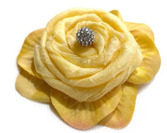 May include: A yellow fabric flower with a single rhinestone center.
