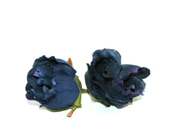 May include: Two dark blue fabric rose buds with green stems. The rose buds are closed and have a velvety texture.