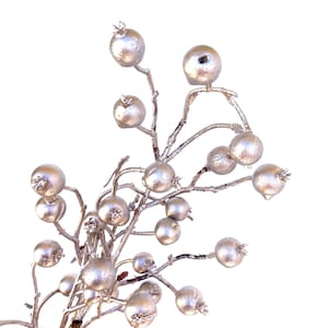May include: A silver spray of berries with a twig-like stem. The berries are round and have a metallic finish.