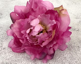 May include: A single, large, pink peony flower with a yellow center. The flower is in full bloom and has many petals.