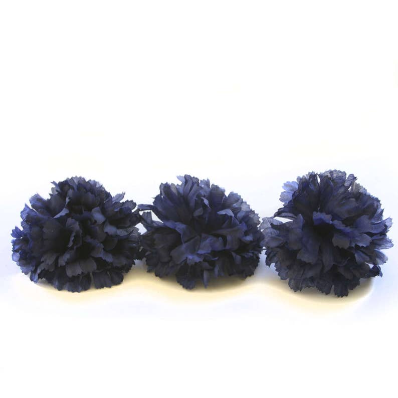 May include: Three navy blue carnation flowers, each with a fluffy, layered texture.