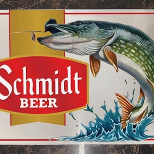May include: Rectangular Schmidt Beer sign featuring a leaping fish with open mouth, water splash, and a red and gold logo. The sign has a white background with a red border.