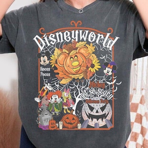 May include: A charcoal gray short-sleeve t-shirt featuring a graphic print with the text Disneyworld, Hocus Pocus, and Mickey Not So Scary Halloween Party. The design includes illustrations of Mickey Mouse, Minnie Mouse, and pumpkins.