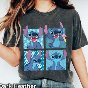 Puede incluir: Camiseta gris oscuro jaspeada con un estampado gr&aacute;fico de cuatro personajes de Stitch de la pel&iacute;cula de Disney Lilo & Stitch. Cada personaje de Stitch est&aacute; en una pose diferente, uno sosteniendo un cono de helado.