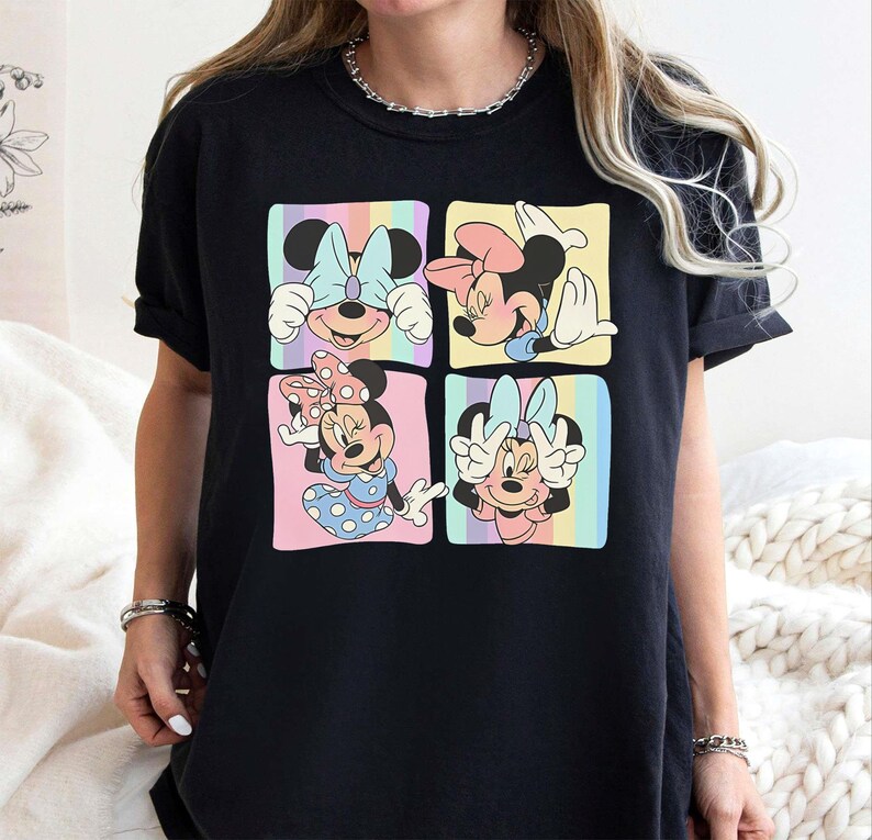 May include: Black t-shirt with a colorful graphic of four different images of Mickey Mouse. Each image shows Mickey Mouse with a different expression and pose.